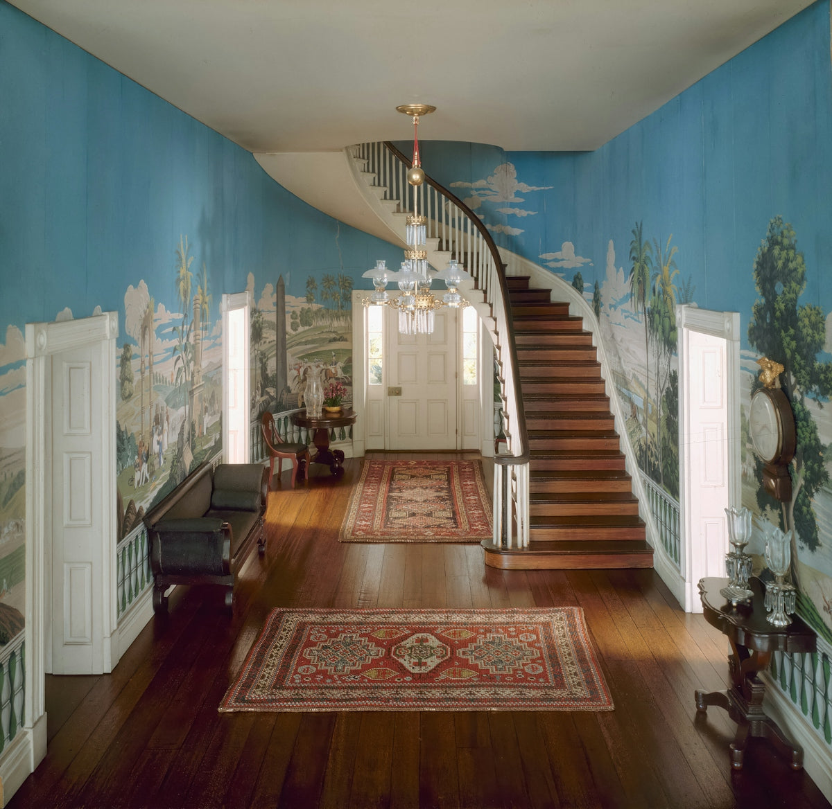 a hallway with a staircase and a painting on the wall