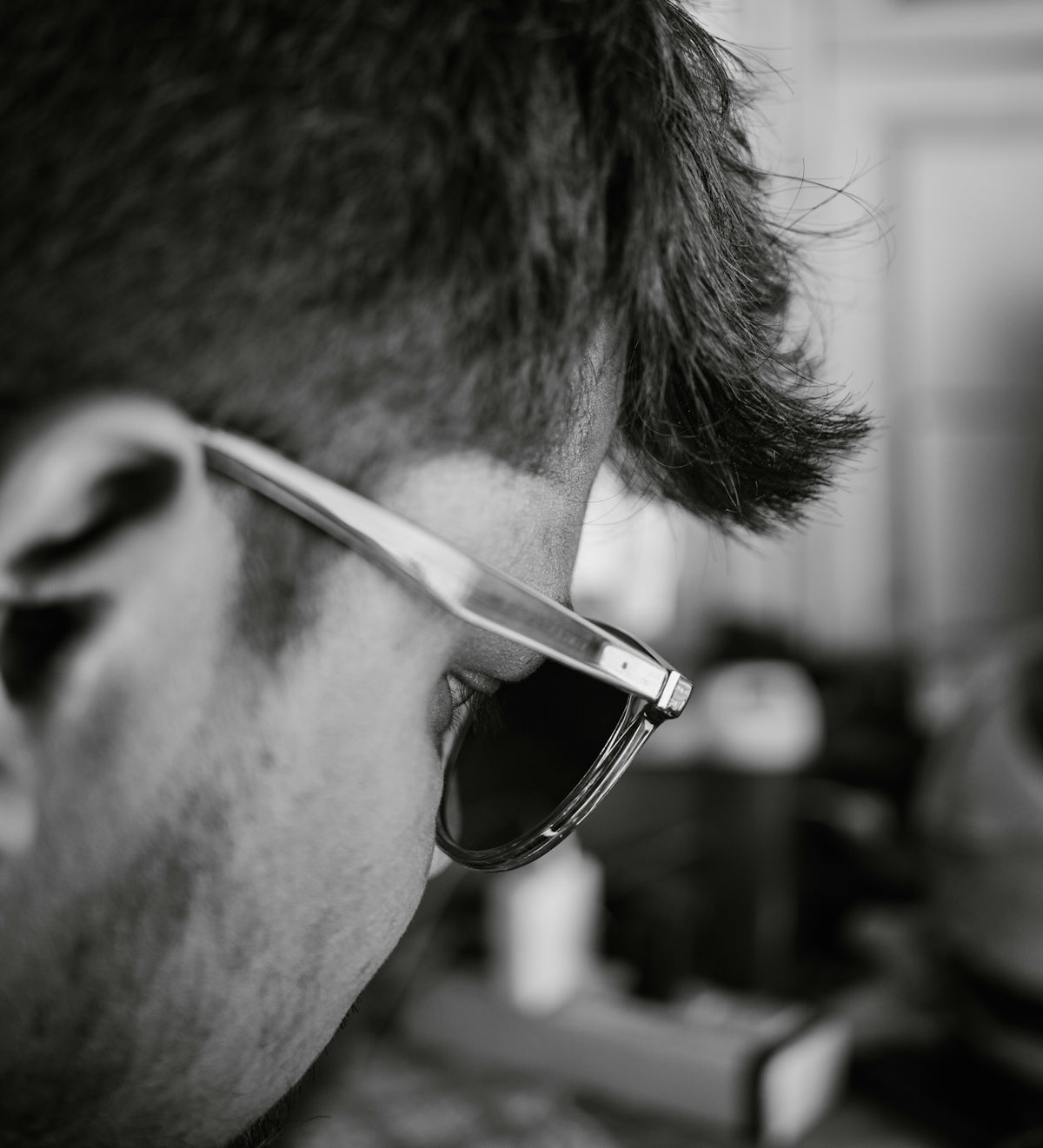A man wearing sunglasses looking at a cell phone