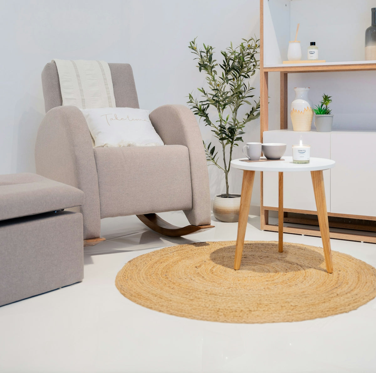 A comfortable rocking chair with an ottoman and side table