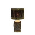 Table lamp with black and gold Greek key patterned shade and ornate dark textured base with gold accents.